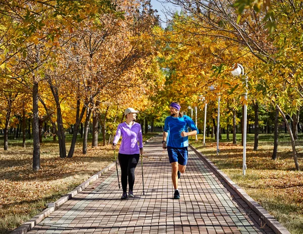 Allenamento Giovani Coppie Nel Parco Autunnale Uomo Jogging Donna Nordic — Foto Stock