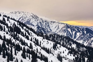 Almatı, Kazakistan'ın gün batımında yüksek karlı dağlar