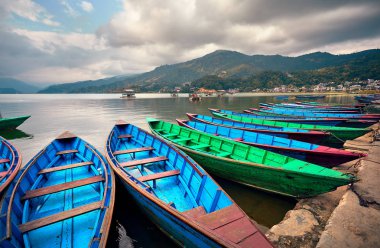 Phewa göl kıyısı Pokhara, Nepal, mavi ve yeşil deniz araçları.