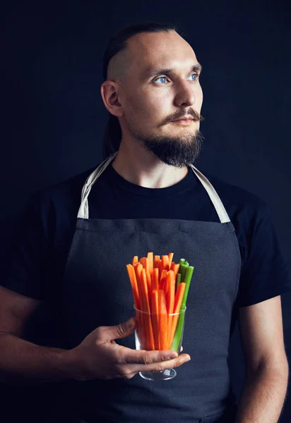 Muž s rozřezaných mrkve a celer na černém — Stock fotografie