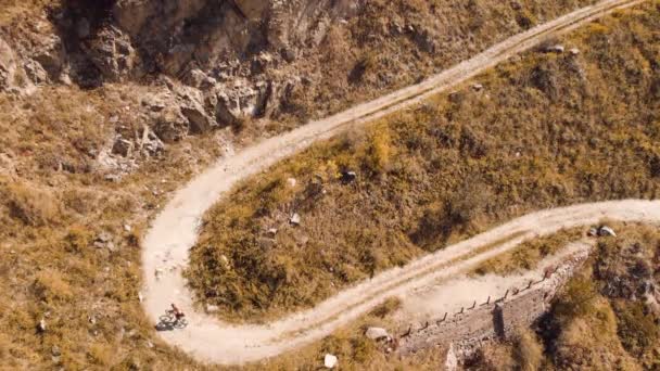 Homem passeio de bicicleta na estrada da montanha disparado por drone — Vídeo de Stock