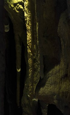 Sarkıtlar üzerinde sert bir ışık ile karanlık bir mağarada