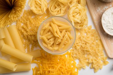 Yapıştır tema. Ahşap arka plan üzerinde makarna çeşitleri. Farfalle, fettuccine, erişte, düdük ve penne rigate