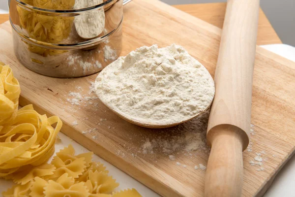 Yapıştır tema. Ahşap arka plan üzerinde makarna çeşitleri. Farfalle, fettuccine, erişte, düdük ve penne rigate — Stok fotoğraf