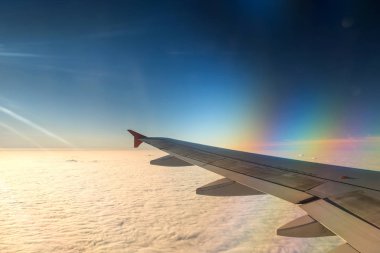 Gündoğumu ve mavi gökyüzü ile uçağın kanat.