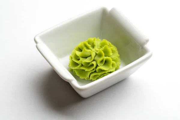 Gedeelte van wasabi in een witte jus boot. — Stockfoto