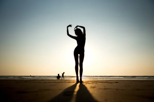 Femme sur la plage au coucher du soleil — Photo