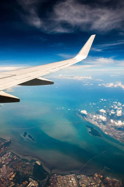 Wing of airplane in cloudy sky