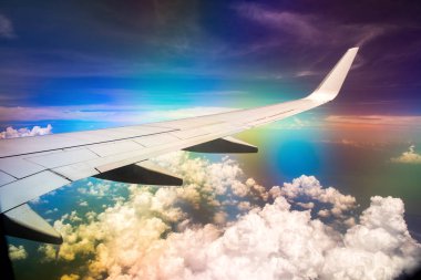 Gökkuşağı etkisi ile bulutlu gökyüzünde uçağın Kanadı