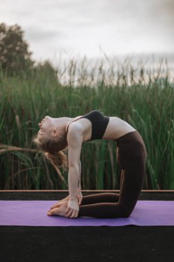 Kız uygulama Yoga sabah erken iskelede