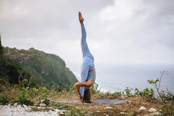 Chica practica yoga cerca del océano . — Foto de Stock