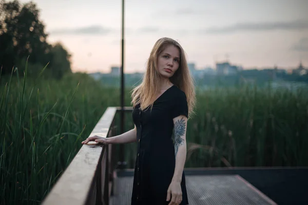 Romantisches Mädchen in schwarzem Kleid geht auf Pier — Stockfoto