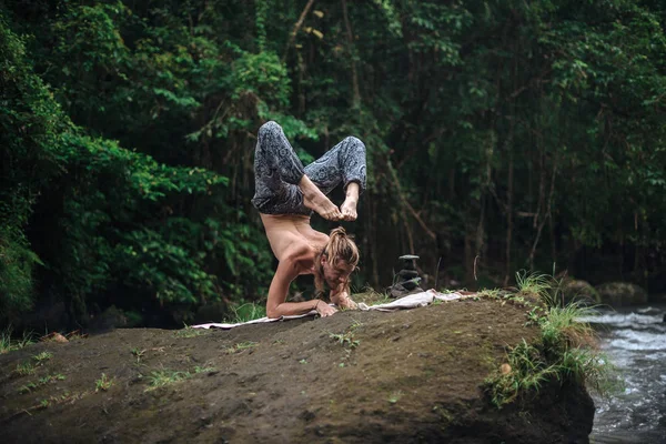 Pratica di yoga e meditazione in natura. Uomo che pratica vicino al fiume — Foto Stock