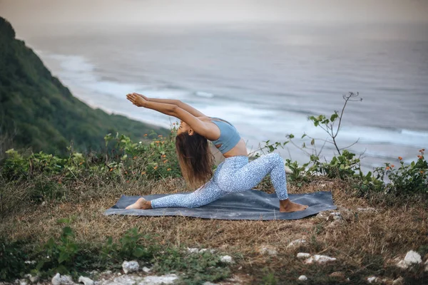 Chica practica yoga cerca del océano . — Foto de Stock