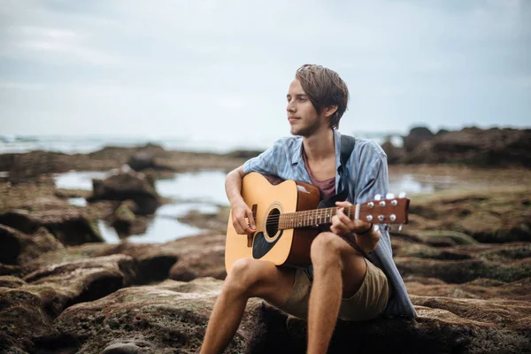 Romantic young man with a guitar on the beach — Stock Photo, Image