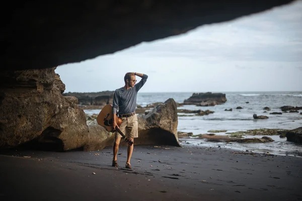 Romanttinen nuori mies kitara rannalla — kuvapankkivalokuva
