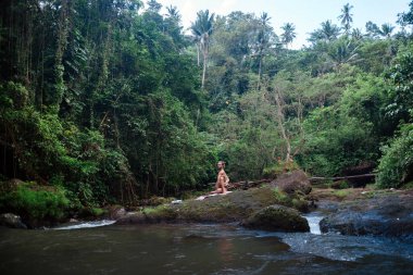 Yoga uygulaması ve doğada meditasyon. Nehir yakınlarında pratik yapan adam