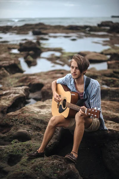 Romantic young man with a guitar on the beach — Stock Photo, Image