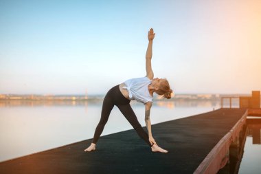 Kız uygulama Yoga sabah erken iskelede