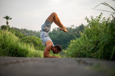 Erkek, dışarıda yoga ve meditasyon pratiği yapıyor.
