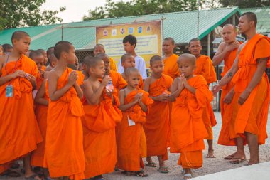Tayland 'daki Phuket' teki Büyük Buda Tapınağı yakınlarında turuncu elbiseli genç Budistler. 28 Nisan 2019.