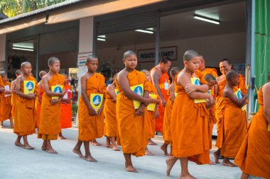Tayland 'daki Phuket' teki Büyük Buda Tapınağı yakınlarında turuncu elbiseli genç Budistler. 28 Nisan 2019.
