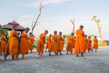 Tayland 'daki Phuket' teki Büyük Buda Tapınağı yakınlarında turuncu elbiseli genç Budistler. 28 Nisan 2019.