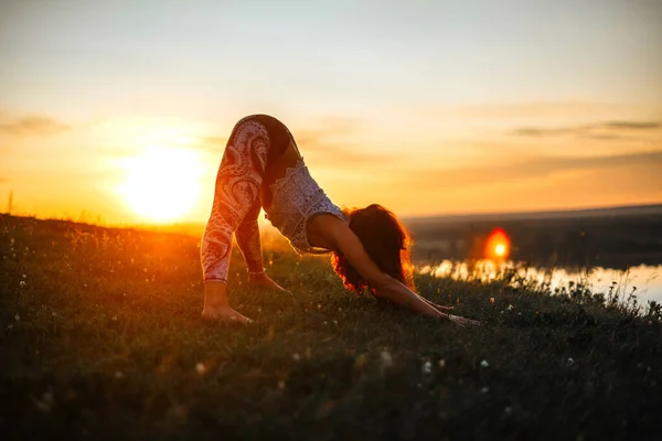 Yoga beoefening en meditatie in de natuur bij zonsopgang. vrouw oefenen in de buurt van grote rivier Kama. — Stockfoto