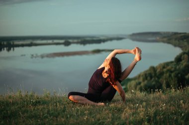 Yoga pratiği ve güneş doğarken meditasyon. Kama nehrinin yanında alıştırma yapan kadın..