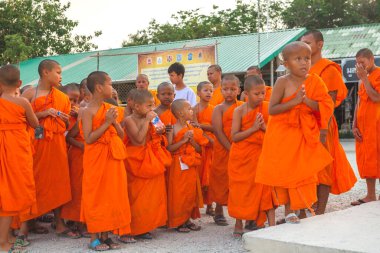Tayland 'daki Phuket' teki Büyük Buda Tapınağı yakınlarında turuncu elbiseli genç Budistler. 28 Nisan 2019.