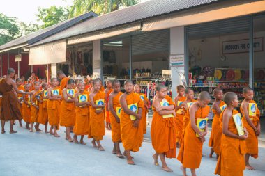 Tayland 'daki Phuket' teki Büyük Buda Tapınağı yakınlarında turuncu elbiseli genç Budistler. 28 Nisan 2019.