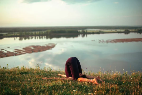 Yoga pratiği ve güneş doğarken meditasyon. Kama nehrinin yanında alıştırma yapan kadın..