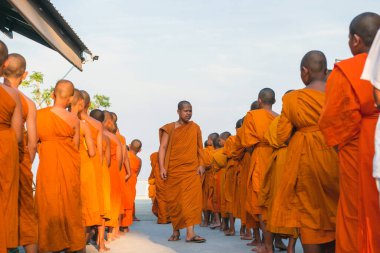 Tayland 'daki Phuket' teki Büyük Buda Tapınağı yakınlarında turuncu elbiseli genç Budistler. 28 Nisan 2019.