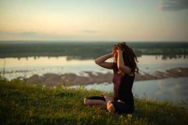 Yoga pratiği ve güneş doğarken meditasyon. Kama nehrinin yanında alıştırma yapan kadın..