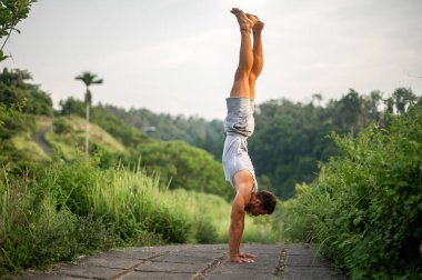 Erkek, dışarıda yoga ve meditasyon pratiği yapıyor.
