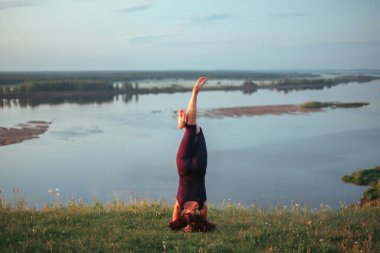 Yoga pratiği ve güneş doğarken meditasyon. Kama nehrinin yanında alıştırma yapan kadın..