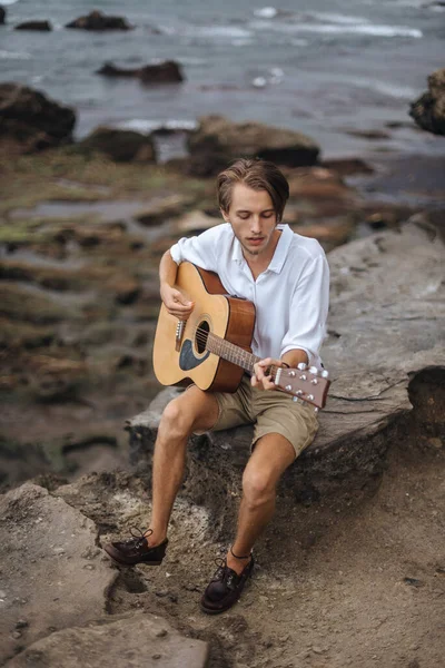 Romantic young man with a guitar on the beach — Stock Photo, Image