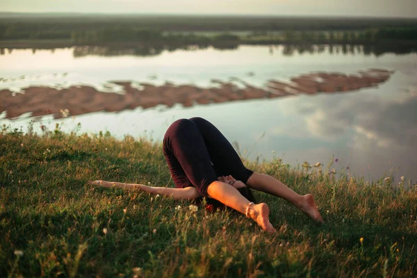 Pratica di yoga e meditazione in natura all'alba. Donna che pratica vicino al grande fiume Kama. — Foto Stock