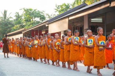 Tayland 'daki Phuket' teki Büyük Buda Tapınağı yakınlarında turuncu elbiseli genç Budistler. 28 Nisan 2019.