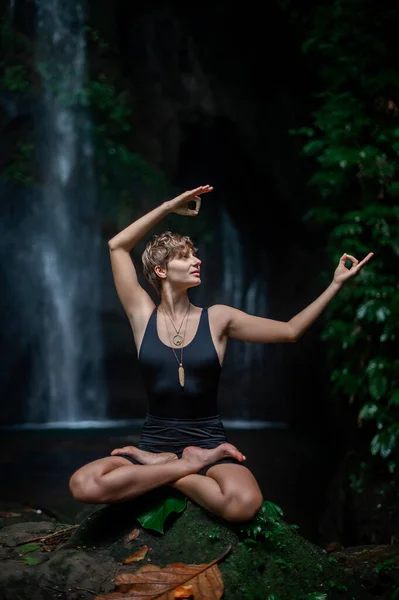 Práctica de yoga y meditación en la naturaleza. Práctica de mujer cerca de cascada. — Foto de Stock