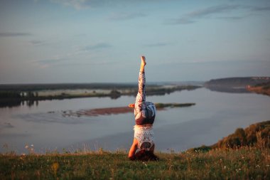 Yoga pratiği ve güneş doğarken meditasyon. Kama nehrinin yanında alıştırma yapan kadın..