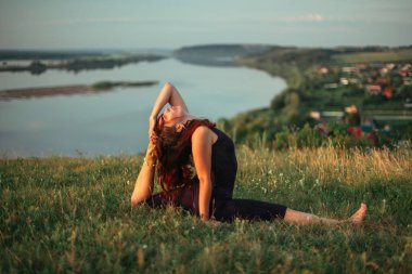 Yoga pratiği ve güneş doğarken meditasyon. Kama nehrinin yanında alıştırma yapan kadın..