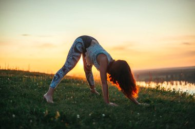 Yoga pratiği ve güneş doğarken meditasyon. Kama nehrinin yanında alıştırma yapan kadın..