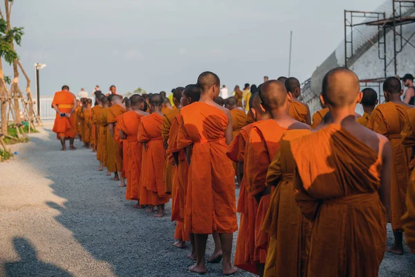 タイのプーケットにある大仏殿近くのオレンジの服を着た若い仏教徒。2019年4月28日. — ストック写真
