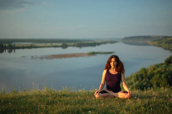 Práctica de yoga y meditación en la naturaleza al amanecer. Mujer practicando cerca del gran río Kama. — Foto de Stock
