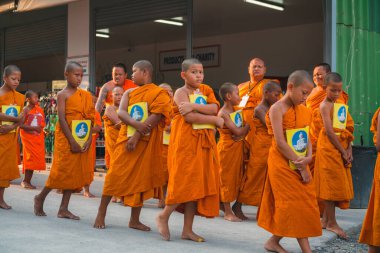 Tayland 'daki Phuket' teki Büyük Buda Tapınağı yakınlarında turuncu elbiseli genç Budistler. 28 Nisan 2019.