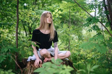 Meditasyon ve doğayla etkileşim pratiği. Yeşil ormandaki kız