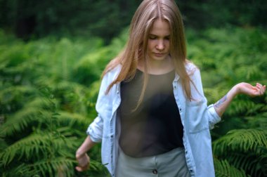 Meditasyon ve doğayla etkileşim pratiği. Yeşil ormandaki kız