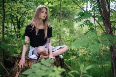 Meditasyon ve doğayla etkileşim pratiği. Yeşil ormandaki kız
