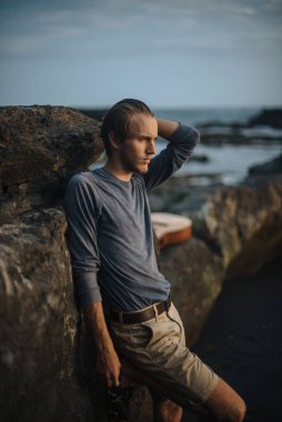 Sahilde gitar çalan romantik bir genç adam.